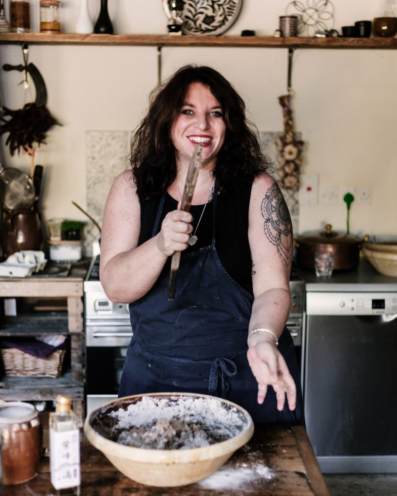 Vanessa holding a sourdough spatula and demonstrating essential sourdough baking equipment for beginners.