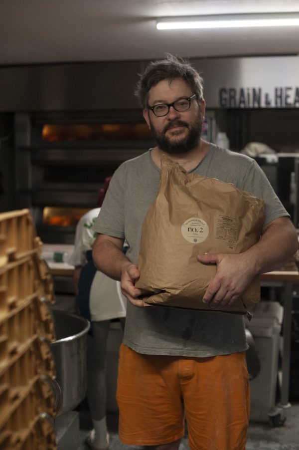 Adam holding 16kg bag of botanical blend flour